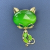 Katzenbrosche mit grünem Katzenauge, weiße Strasssteine, goldfarbenes Metall, 34×58 mm+