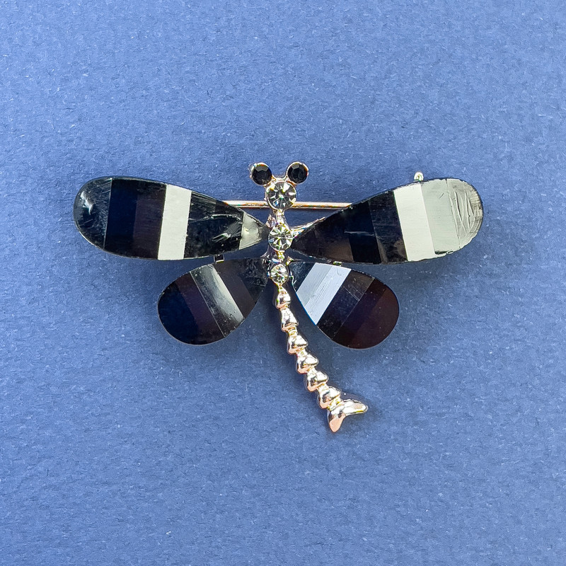 Schmetterlingsbrosche «Schmetterling» mit weißen und grauen Strasssteinen, Metall in Schwarz-Gold-Ton, Durchmesser ca. 40 mm, Länge ca. 30 mm