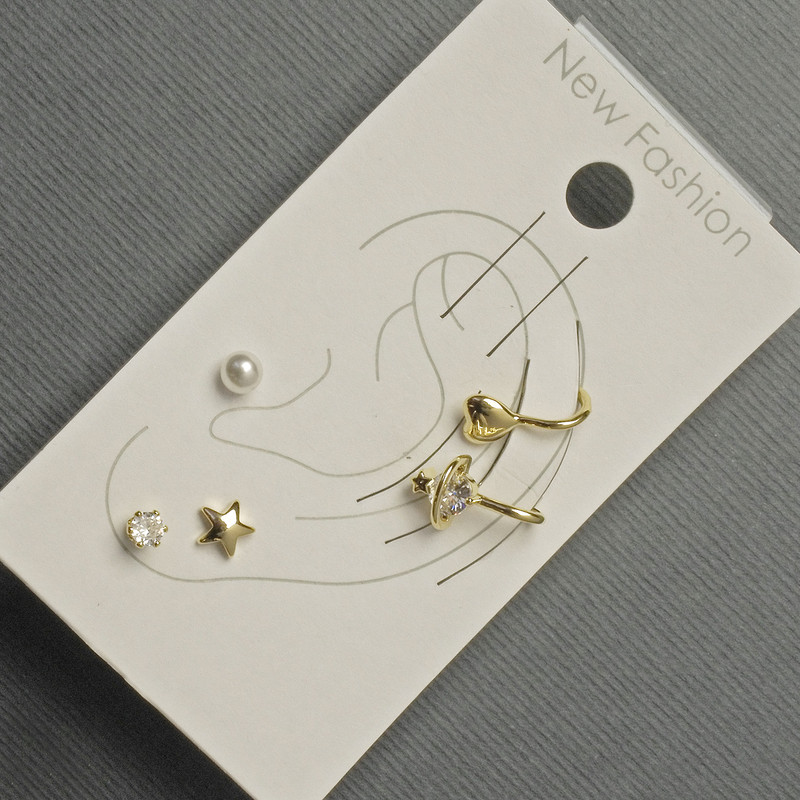 Ohrstecker und Ohrklemmen am Ohr – goldfarbenes Metall, weiße Strasssteine und Perle