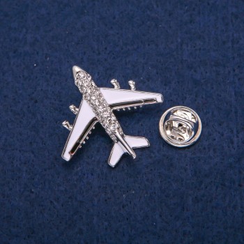 Brosche Flugzeug mit weißer und schwarzer Emaille, Strasssteinen, silberfarbenem Metall 29×30 mm