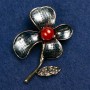 Brosche „Blume mit Karneol-Perle und Emaille“ 47×60 mm, goldfarbenes Metall