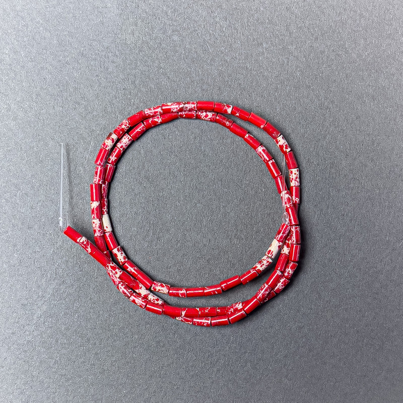 Varizit-Perlen rot (gepresst), facettiert, Ø ca. 2×4 mm, Länge ca. 38 cm, auf Faden