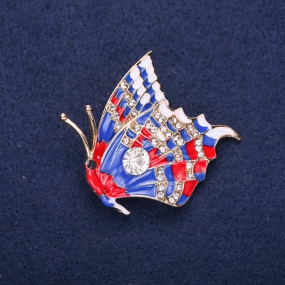 Брошка Метелик з білими стразами синя і червона емаль 40х38мм жовтий метал