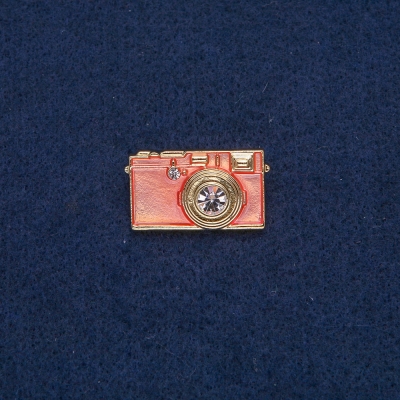 Брошка Фотоапарат золотистий метал з рожевою емаллю і білими каменями 30х17 мм + -